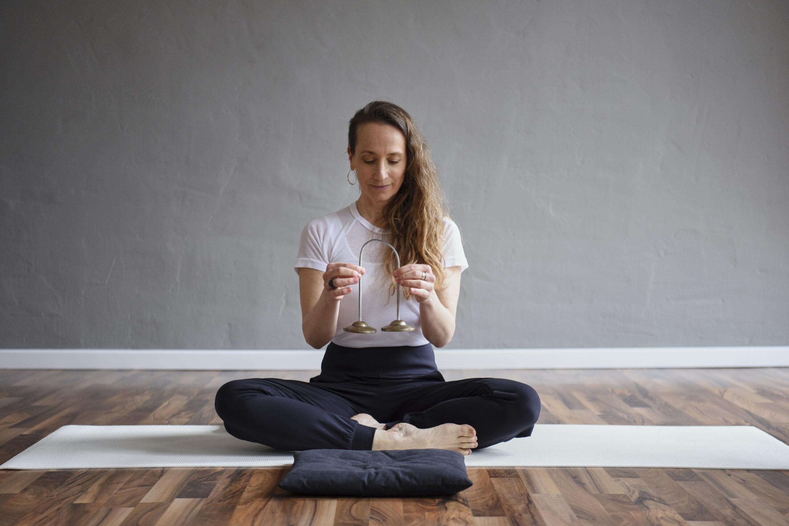 Angela im Meditationssitz mit Zimbel